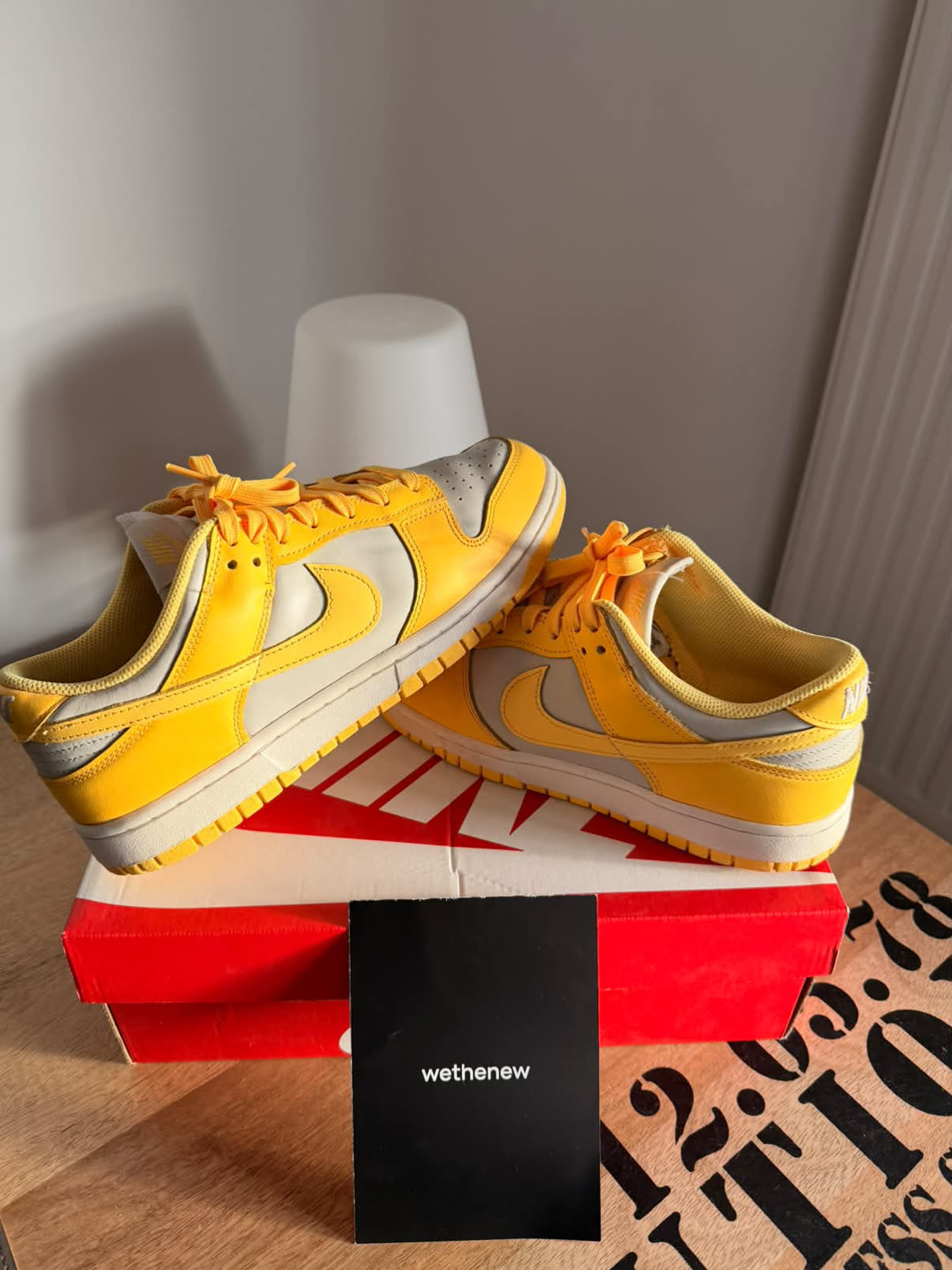 Nike Dunk Low jaunes et grises posées sur leur boîte